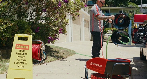 Professional Sydney plumber using advanced drain camera technology to inspect underground drainage systems